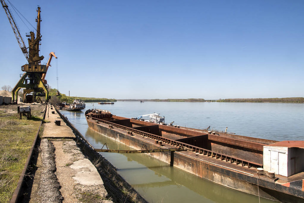 晴れた日の川港でバルク貨物バージと産業クレーン - 写真・画像