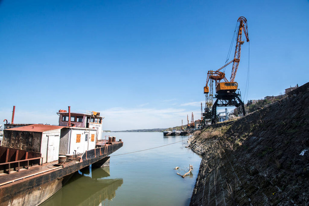 Řeka volně ložený nákladní loď a průmyslové jeřáby v říčním přístavu v slunečný den - Fotografie, Obrázek