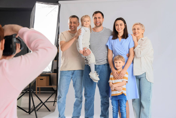 Чоловік фотограф фотографує велику сім'ю в студії - Фото, зображення