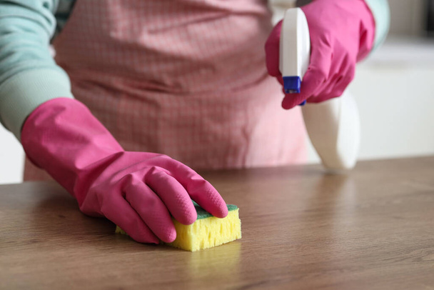 Mujer limpiando mesa de madera con esponja en casa, primer plano - Foto, imagen
