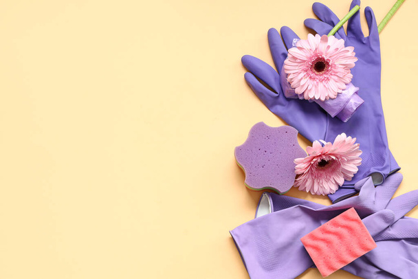 Latex gloves with sponges, garbage bags and spring flowers on beige background - Photo, Image