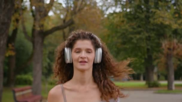 Ευτυχισμένος ενεργό λεπτό κίνητρο Καυκάσιος γυναίκα δρομέας κορίτσι δρομέας κυρία θηλυκό προετοιμαστούν για μαραθώνιο τρέχει μόνη της στο πάρκο της πόλης τρέχει τζόκινγκ αθλητική δραστηριότητα fitness απολαμβάνοντας μουσική τραγούδι ήχου στα ακουστικά - Πλάνα, βίντεο