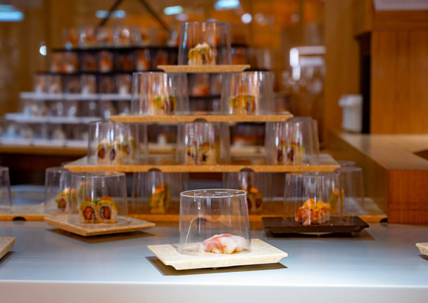 Japanse keuken, modern restaurant met sushi, sashimi en andere Japanse gerechten geserveerd op bewegende riem over restaurant, self-service lunch cafe - Foto, afbeelding
