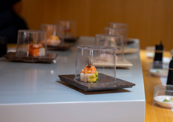 Japonská kuchyně, moderní restaurace se sushi, sašimi a dalšími japonskými pokrmy podávanými na pohyblivém pásu přes restauraci, samoobslužná kavárna - Fotografie, Obrázek
