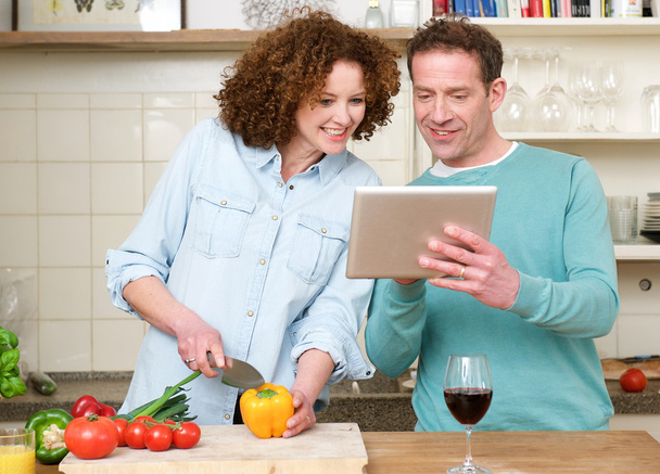 Felice uomo e donna guardando tablet in cucina
 - Foto, immagini