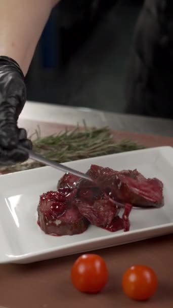 Kuchařská ozdoba Grilovaný hovězí steak podávaný s třešňovou omáčkou na bílém talíři v restauraci. Koncept jídelního lístku. Svislé zobrazení - Záběry, video
