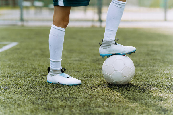 um jogador de futebol menino em um uniforme verde corre com a bola no campo de futebol - Foto, Imagem