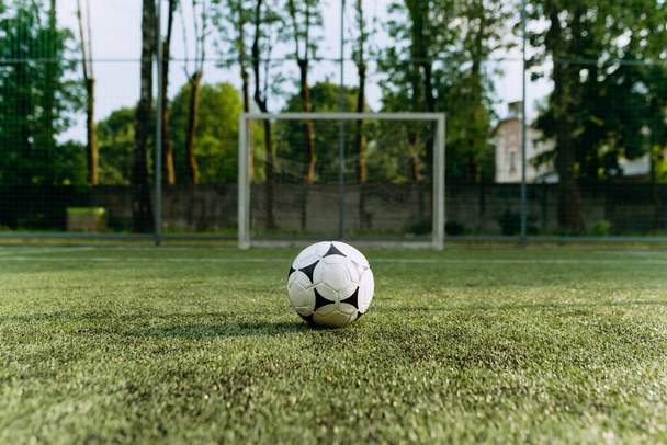 a bola de futebol fica no campo de futebol na frente do gol. bola de futebol em relva artificial - Foto, Imagem