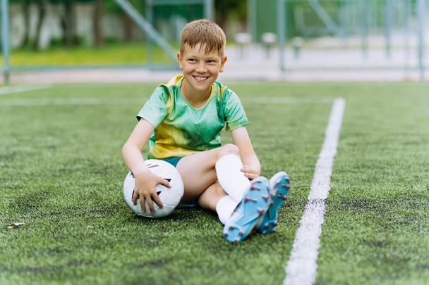 chlapec fotbalista ve sportovní uniformě na fotbalovém hřišti - Fotografie, Obrázek