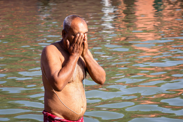 devoto rezando después de bañarse en agua bendita del río por la mañana desde ángulo plano - Foto, imagen