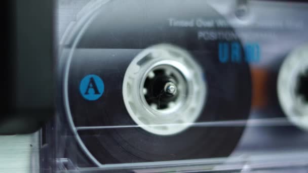 Macro close-up van audio cassette tape spelen in vintage speler, een kant 4k - Video