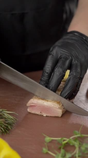 Шеф розрізає тунець ножем. Готуємо здорові страви. Вертикальний перегляд - Кадри, відео