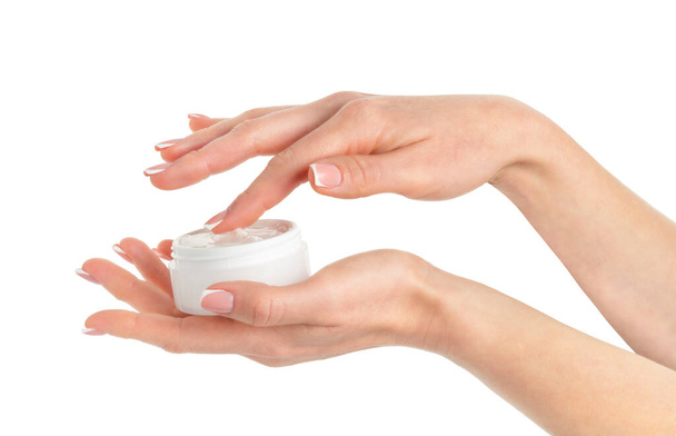 Frasco de crema cosmética de mano femenina sobre fondo blanco. - Foto, Imagen
