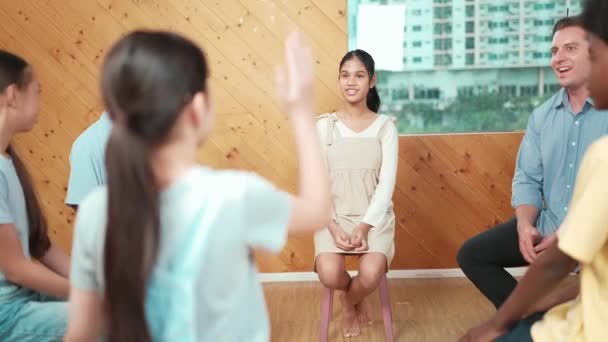 Young student smiling while listening other student in meeting or group discussion. Cute teenager talking about her experience and sharing to friends in mixed races. Creative education. Edification - Footage, Video