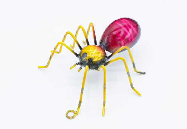 Metalli seinä taidetta hämähäkki hämähäkki, punainen, violetti keltainen väri 8 jalat ja suuri vatsa eristetty valkoisella pohjalla. tehty ripustaa sisä- tai ulkotiloissa - Valokuva, kuva