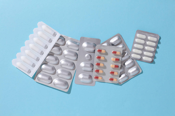 Vari farmaci, blister di pillole su uno sfondo blu. Concetto di medicina - Foto, immagini