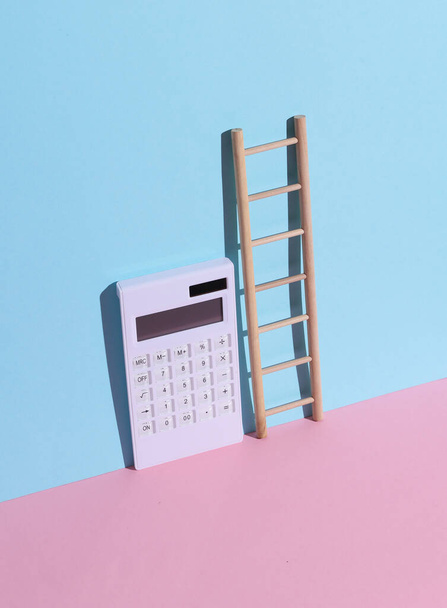 Calculator with a ladder on a blue-pink background. Leadership concept. Career growth. Business and finance - Photo, Image