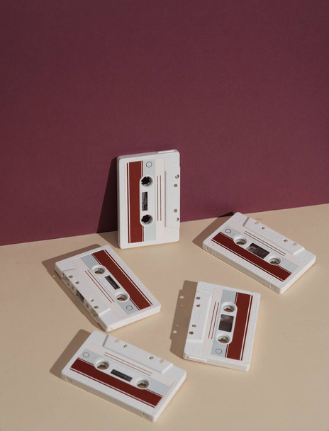 Retro 80s audiocassettes op Bourgogne beige achtergrond met schaduw. Creatieve layout, minimalisme, muziekliefhebber - Foto, afbeelding