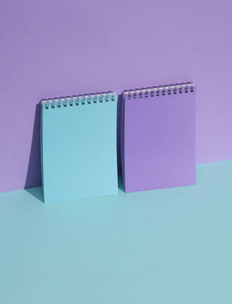 Fialové a modré zápisníky na pastelovém pozadí se stínem. Kreativní uspořádání, minimalismus - Fotografie, Obrázek