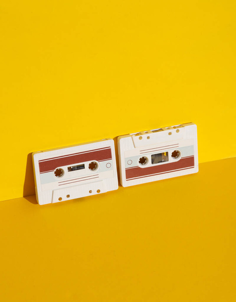 Retro 80s audiocassettes op gele achtergrond met schaduw. Creatieve layout, minimalisme, muziekliefhebber - Foto, afbeelding