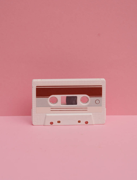 Outdated technologies. Retro 80s audio cassette on pink background. Creative layout - Photo, Image