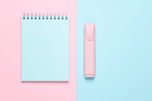 Cuaderno con un marcador sobre un fondo azul-rosa. Vista superior - Foto, imagen