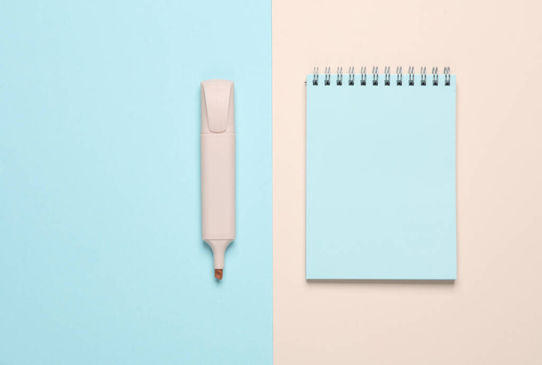 Cuaderno con un marcador sobre un fondo azul beige. Vista superior - Foto, imagen
