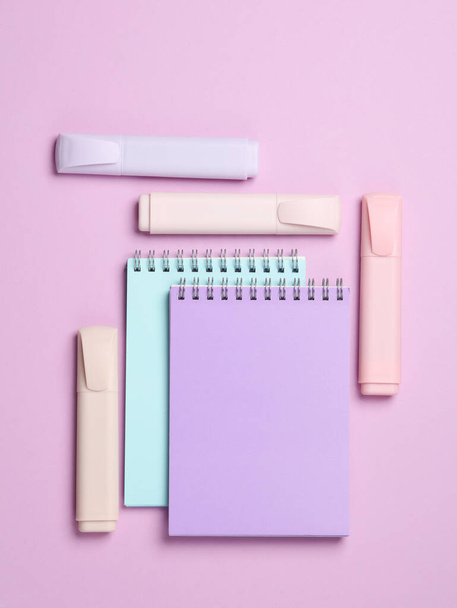 Marcadores ou canetas coloridas com cadernos sobre fundo pastel. Layout criativo. Vista superior - Foto, Imagem
