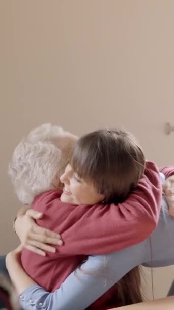 Powolny film z uroczą wnuczką obejmującą babcię w geriatrii - Materiał filmowy, wideo