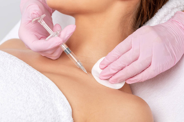 Cosmetologist makes rejuvenating anti wrinkle injections on the neck - Photo, Image