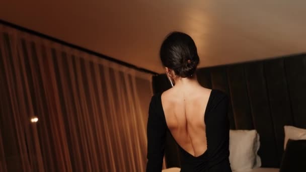 Elegáns nő fekete ruhában pózol egy apartmanban.Nő fekete ruhában és piros ajkak pózol a kamera Divatfotózás koncepció 4K - Felvétel, videó