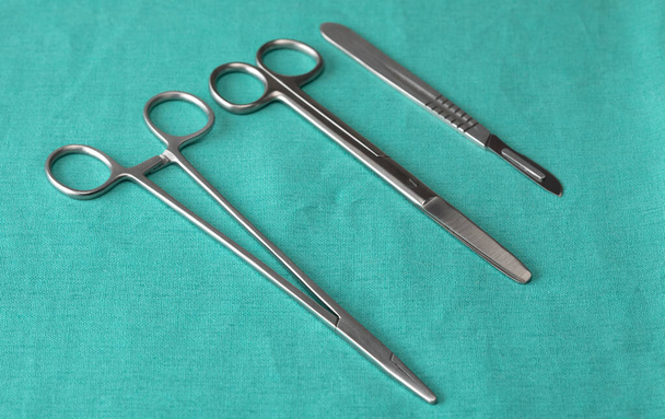 Instrumentos estériles sobre fondo verde de cerca. Preparación de instrumentos para cirugía. - Foto, Imagen