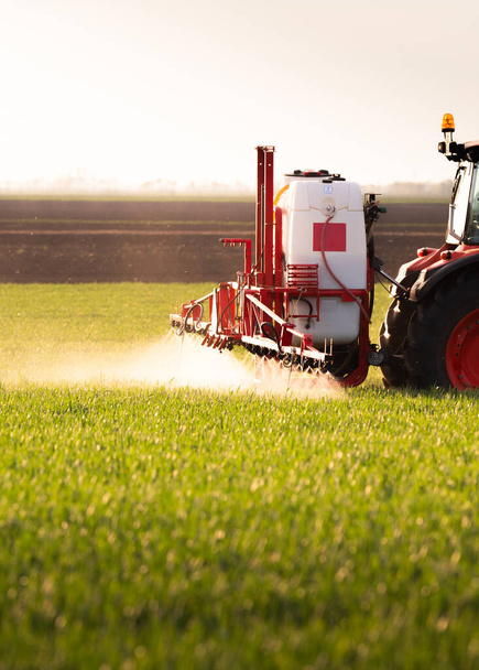Traktor rozstřikuje pesticidy po zeleném poli - Fotografie, Obrázek