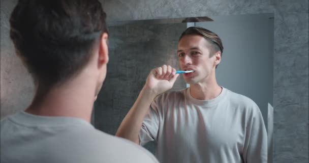 Tandheelkundige zorg voorhoede man poetst tanden badkamer close-up benadrukt mondhygiëne voor tandvlees gezondheid behoud. Mondelinge hygiëne Integrale gezondheid regime Focus mondhygiëne voorop - Video