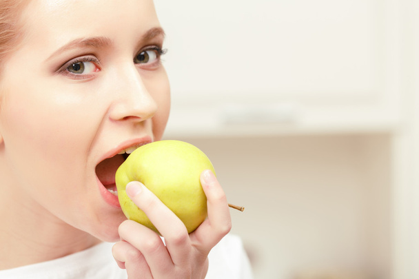 Young lady biting an apple - Фото, изображение
