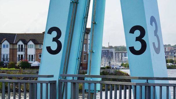 Bahía de Cardiff, Cardiff, Gales 25 de septiembre de 2023: Grandes números negros 1, 2 y 3 están pintados encima de las cerraduras de la presa de Cardiff. Las esclusas permiten la entrada de pequeñas embarcaciones desde la bahía de Cardiff con marea alta. - Foto, Imagen