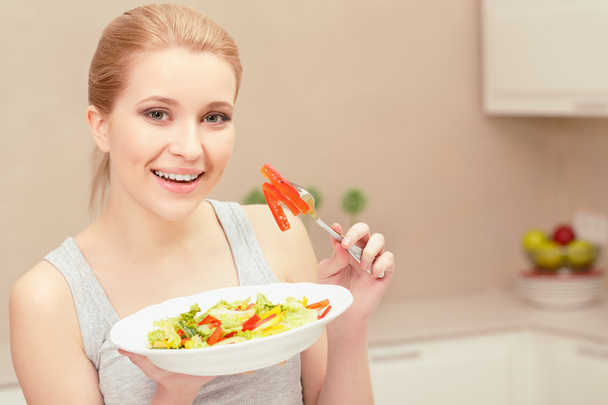 Young woman cooks salad - 写真・画像