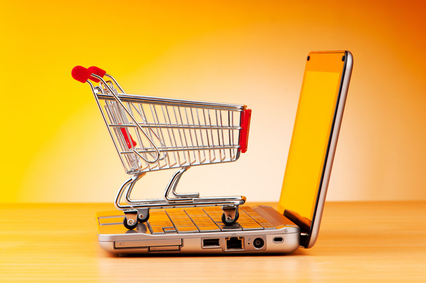 Internet concepto de compras en línea con ordenador y carrito
 - Foto, Imagen