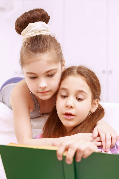 Pair of little girls reading book - Foto, immagini