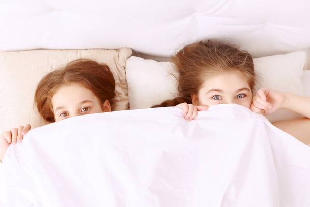 Little hilarious girls covered with blanket. - Foto, imagen