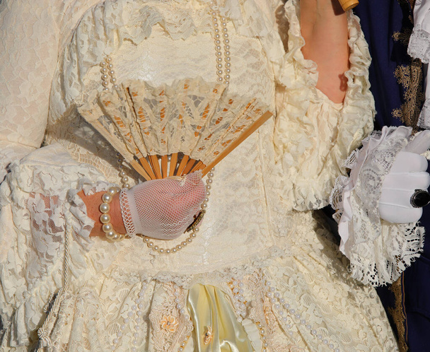 Close-up de mão luva segurando fã de senhora nobre em roupas antigas e luxuosas - Foto, Imagem