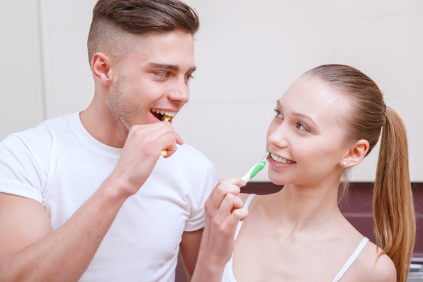 Young beautiful couple cleaning teeth - Fotó, kép