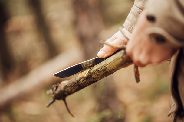 Girl cuts a stick a knife - Photo, image