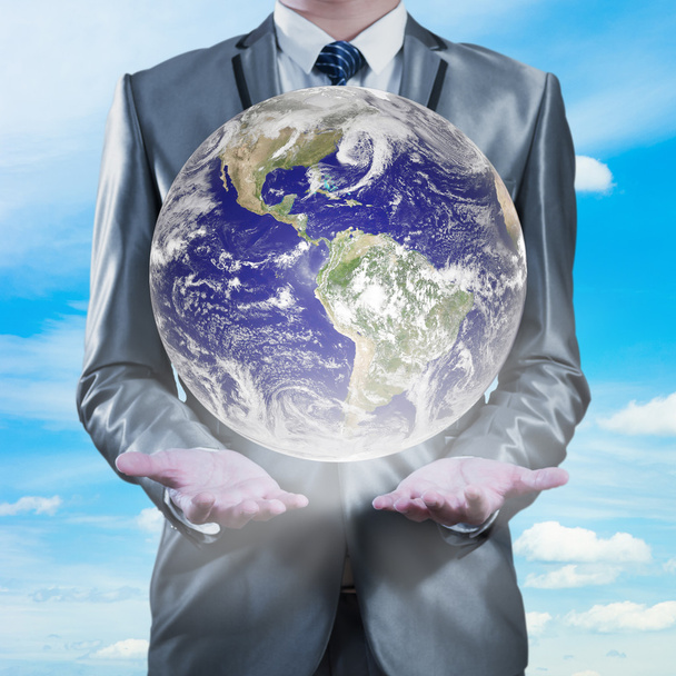 επιχειρηματίας που κατέχουν τη γη με τον ουρανό στο παρασκήνιο, globa επιχειρήσεων - Φωτογραφία, εικόνα