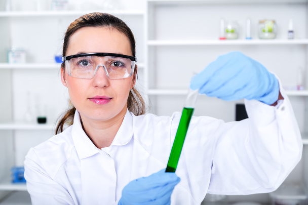 жінка-дослідник зі скляним обладнанням в лабораторії
. - Фото, зображення