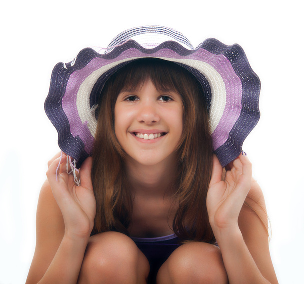 gyönyörű tizenéves lány, lila ruhában és lila kalapban pózol. - Fotó, kép