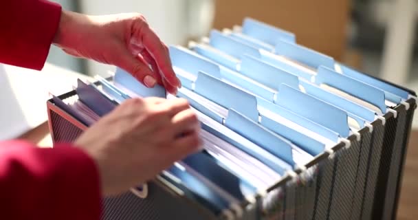 Les mains d'une femme d'affaires trient les documents dans une boîte, gros plan. Organisation de l'information sur le sujet - Séquence, vidéo