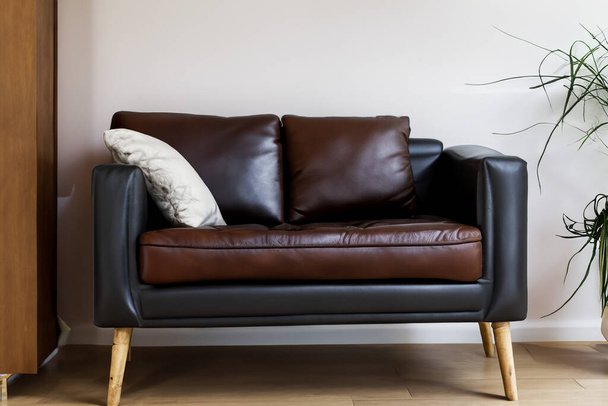 Σαλόνι. Σαλόνι με δερμάτινη πολυθρόνα σε άδειο φόντο τοίχου. Εσωτερικό του σύγχρονου σαλονιού με μαύρη δερμάτινη πολυθρόνα και λάμπα. Μοντέρνο σαλόνι με καναπέ και τραπεζάκι σαλονιού. - Φωτογραφία, εικόνα