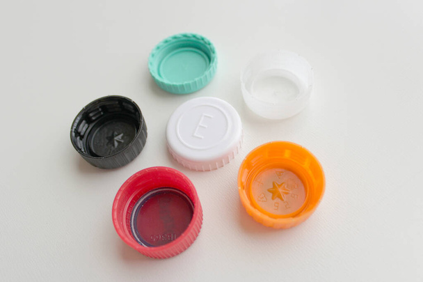 Bando de tampas de garrafa de plástico de seis cores em fundo cinza - Foto, Imagem