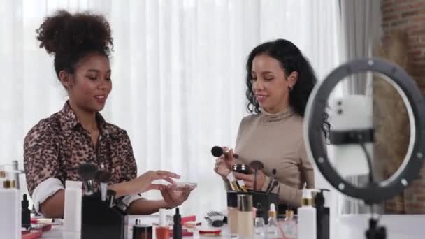 Zwei Influencerinnen drehen Live-Streaming-Video-Review Make-up entscheidenden sozialen Medien oder Blog. Glückliches junges Mädchen mit Kosmetikstudio-Beleuchtung für Marketing-Aufnahmen, die online ausgestrahlt werden. - Filmmaterial, Video